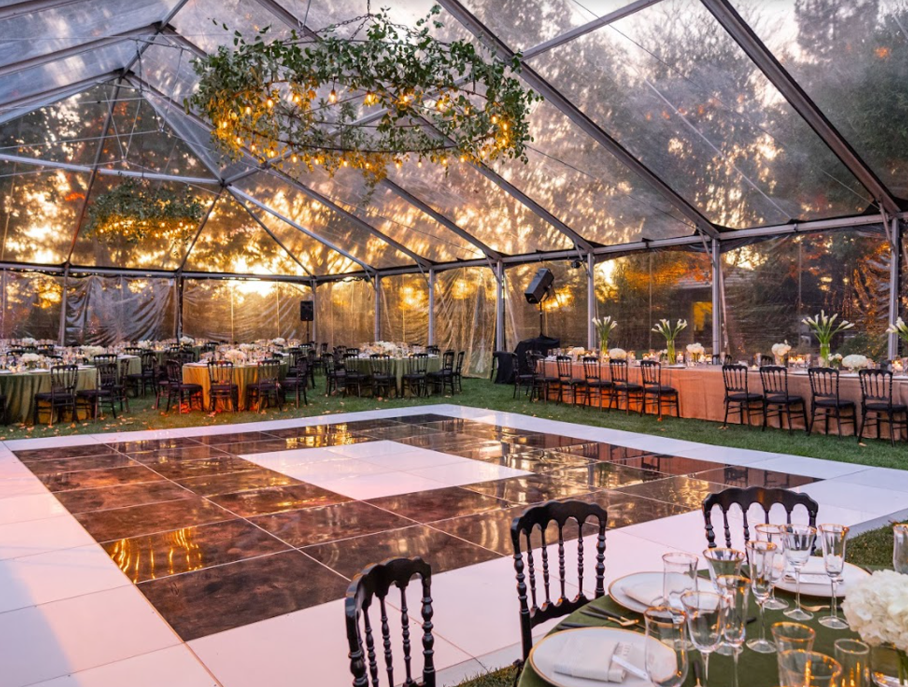 outdoor dance floor covered by canopy with dining tables